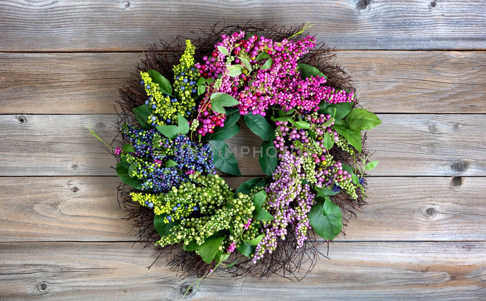 Colorful artificial wreath made of flowers and leaves on vintage by tab1962