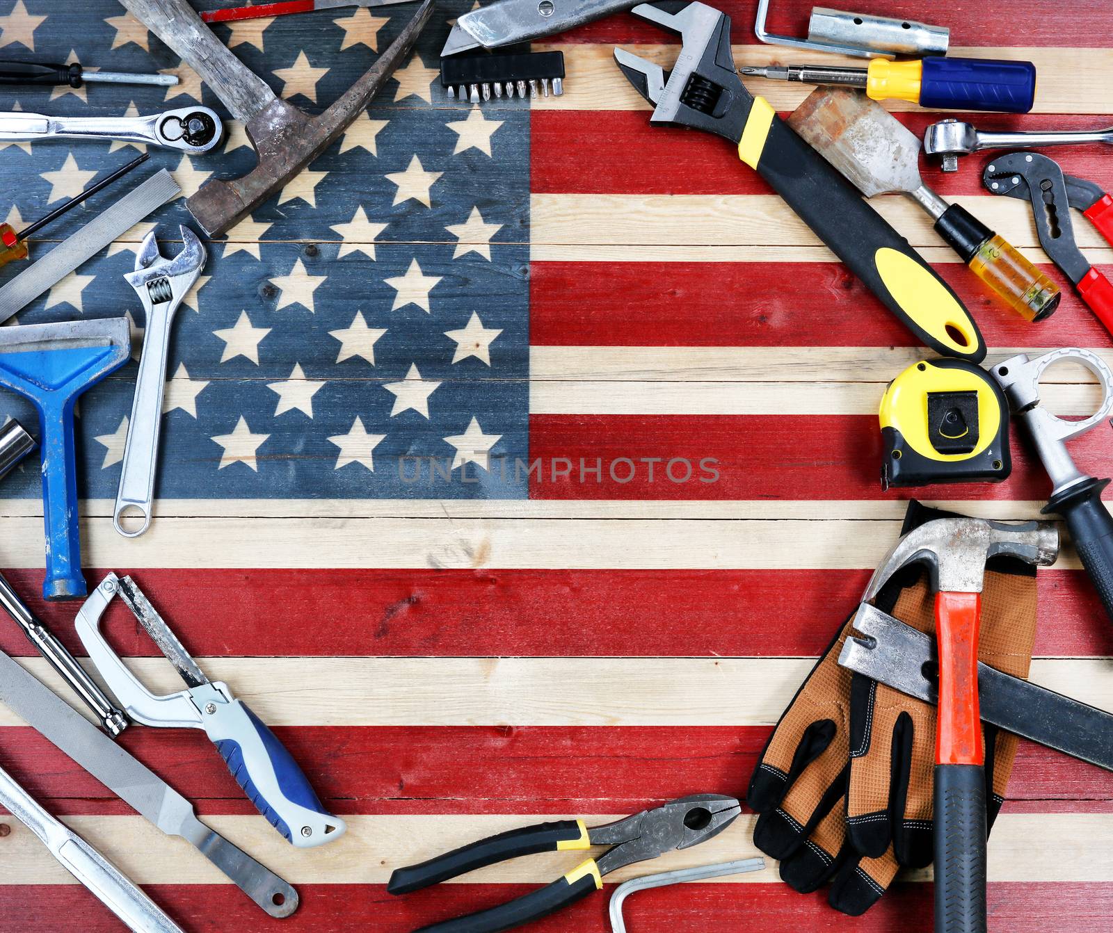 Labor Day concept with circle border of industrial worker tools over distressed United States wooden flag background 