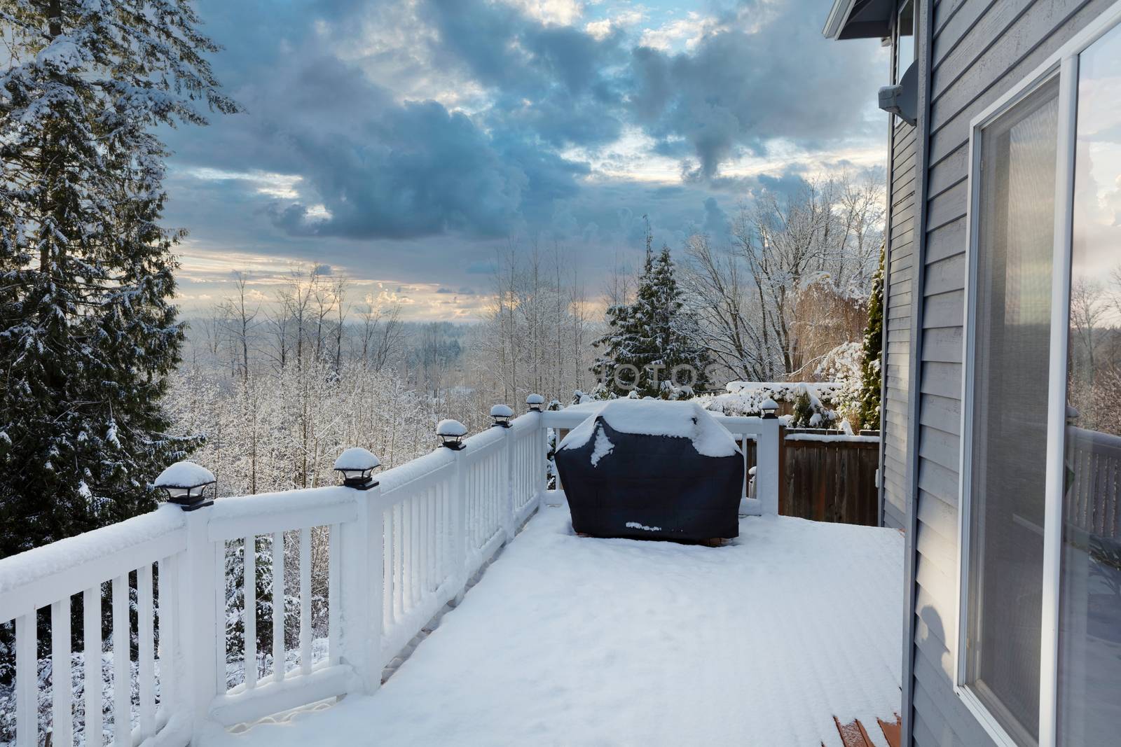 Home outdoor deck closed for the winter with snow on BBQ cooker  by tab1962