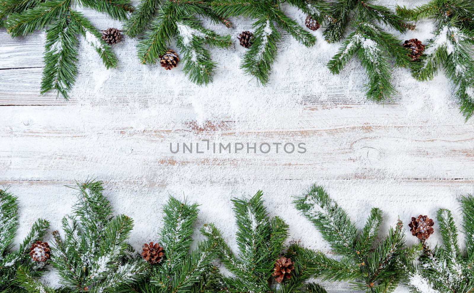 Snowy Christmas branches on rustic white wooden background  by tab1962