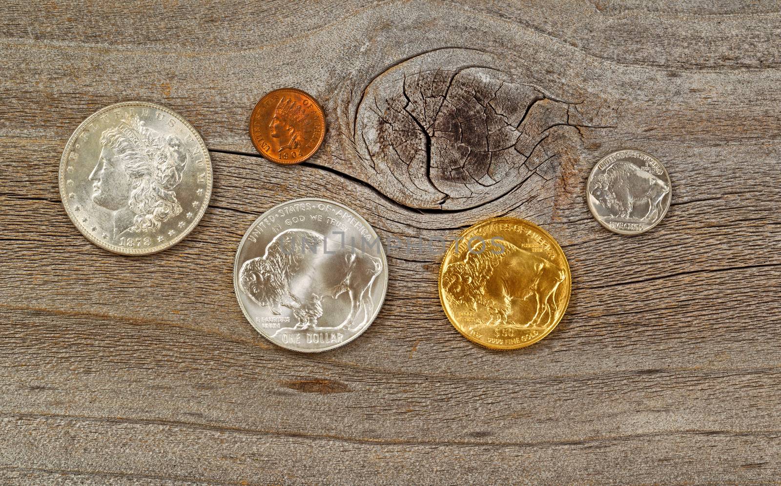 United States Mint issued American vintage coins, consisting of silver, gold and nickel metals, on rustic wood. 