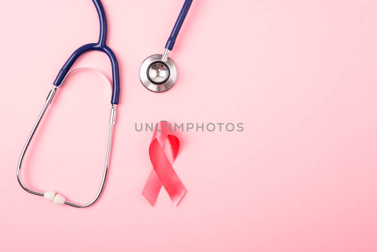Breast Cancer Awareness Month Health concept, top view flat lay pink ribbon and stethoscope on pink background with copy space for your text