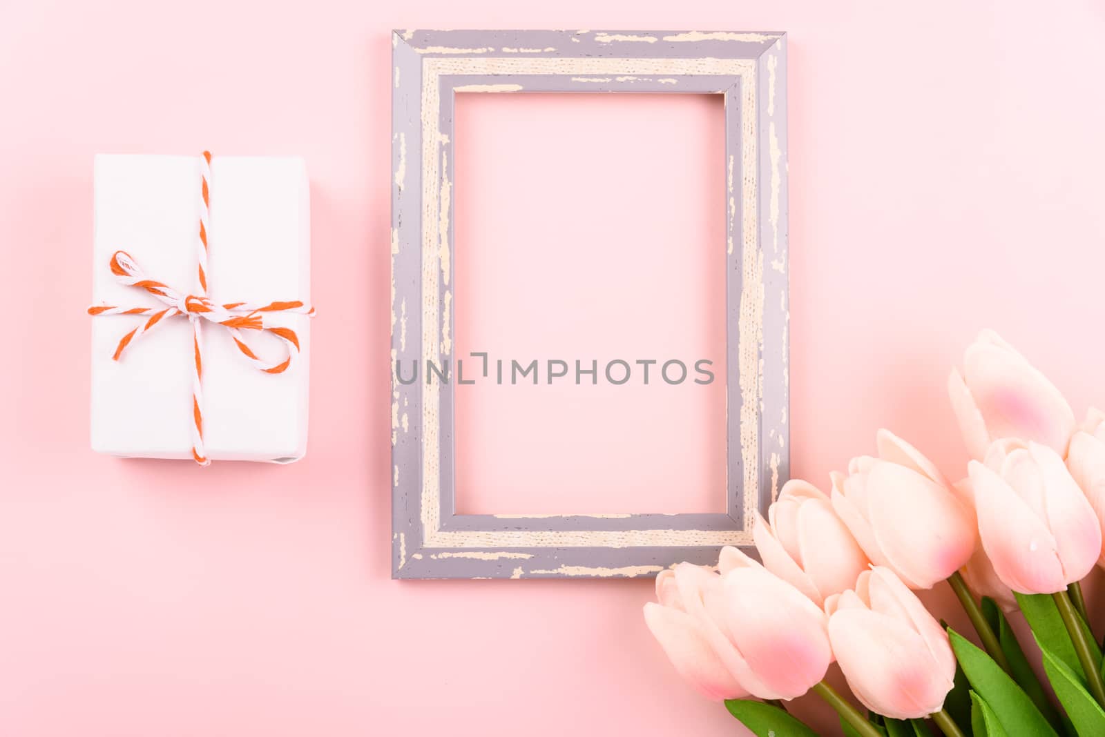 Happy Women's Day, Mother's Day concept. top view flat lay photo frame, gift box and Tulip flower on pink background, copy space for your text