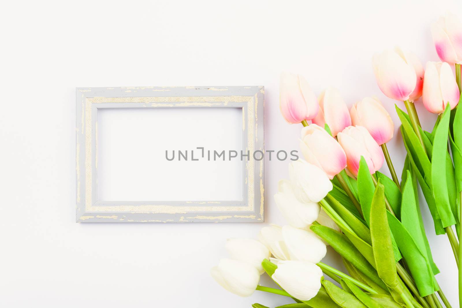 Happy Women's Day, Mother's Day and Valentine's Day concept. top view flat lay Tulip flower and photo frame on white background, copy space for your text