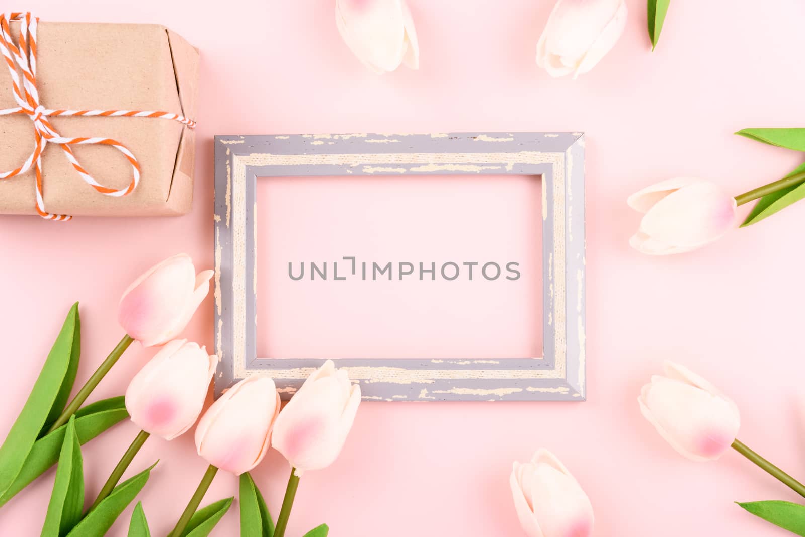 Happy Women's Day, Mother's Day concept. top view flat lay photo frame, gift box and Tulip flower on pink background, copy space for your text