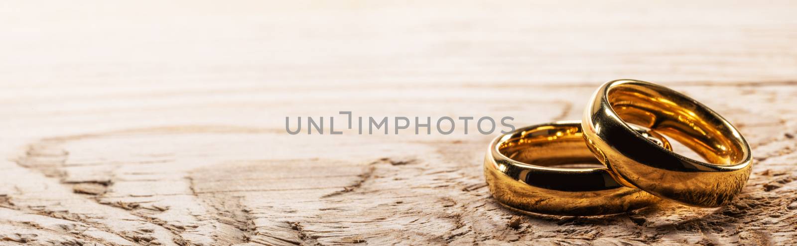Golden wedding rings on wood by Yellowj