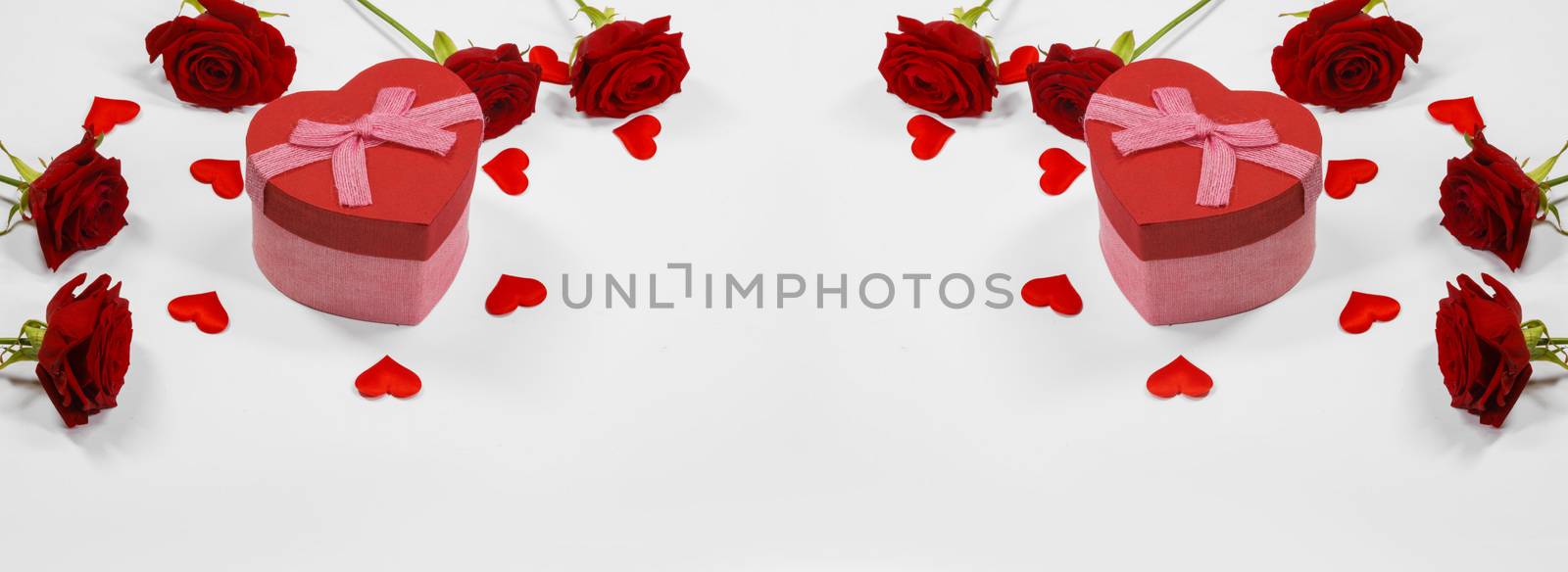 Red heart shaped gift box with roses and paper hearts isolated on white background
