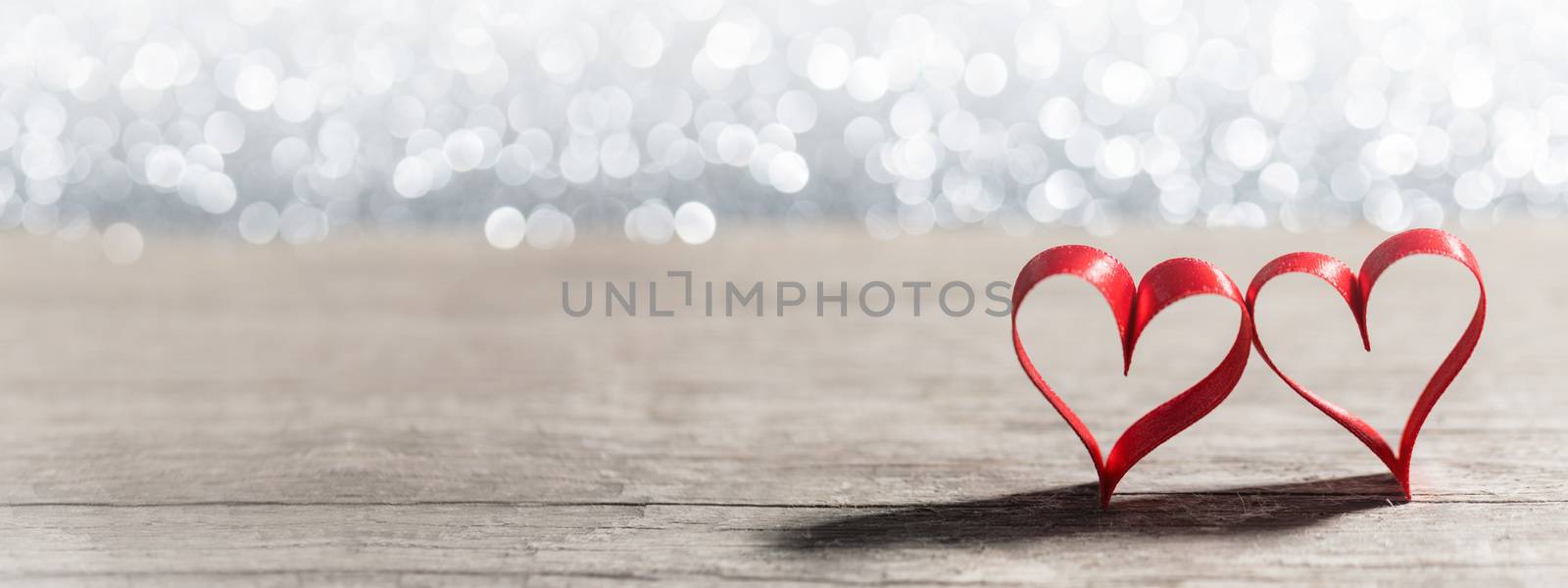 Two red ribbon hearts on glitter background with copy space for text, Valentines day concept