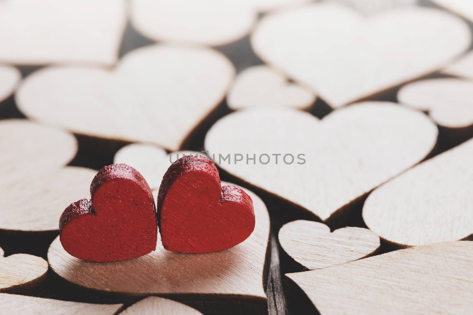 Many wooden colorless hearts background, two red special ones true love concept