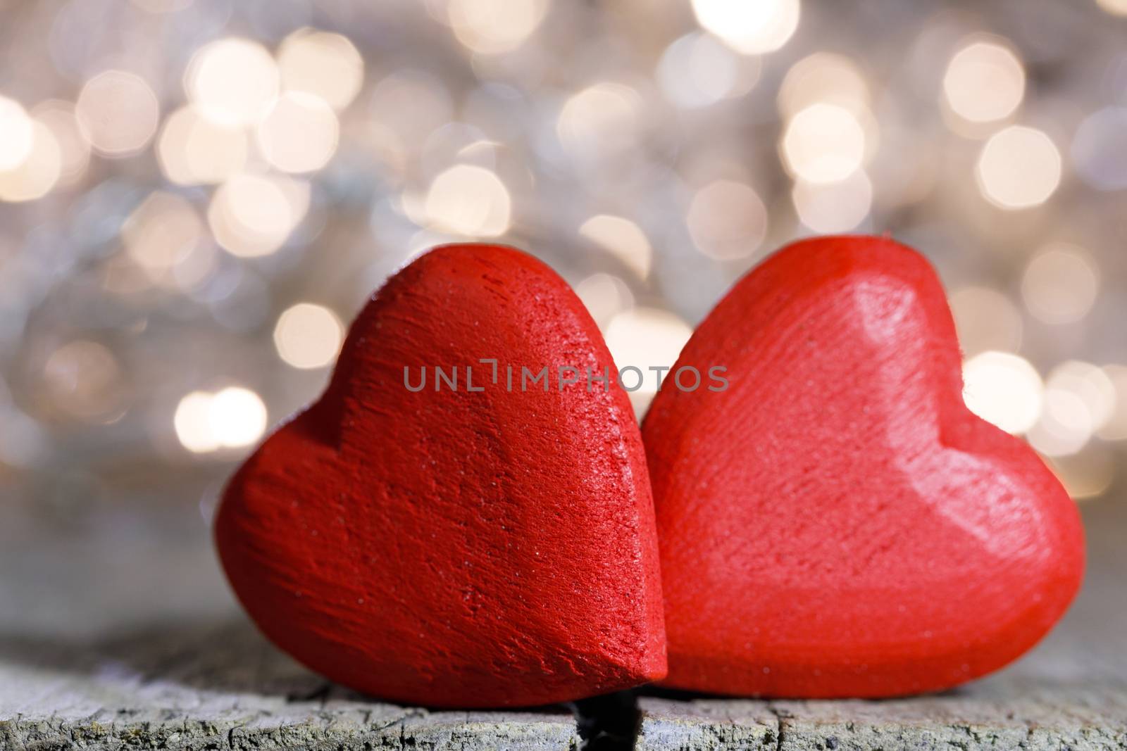 Two red wooden hearts symbol of love on background with beautiful bokeh party lights, Saint Valentine Day celebration