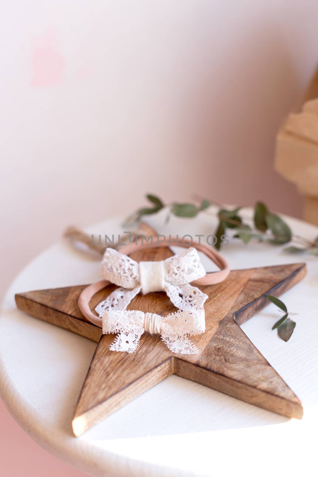 Beautiful fashion accessory for baby girls. Handmade accessories lace and stars on elastic band on white and brown background. Concept of children's clothing