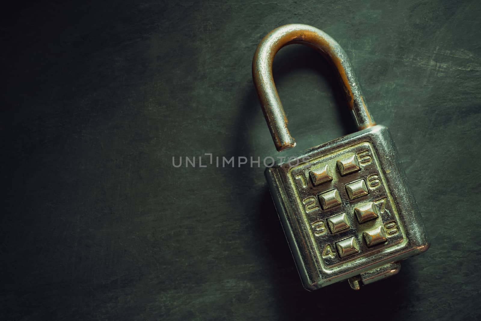 Combination padlock on blackboard background. Top view and copy space. Concept of safety and secret in vintage style.