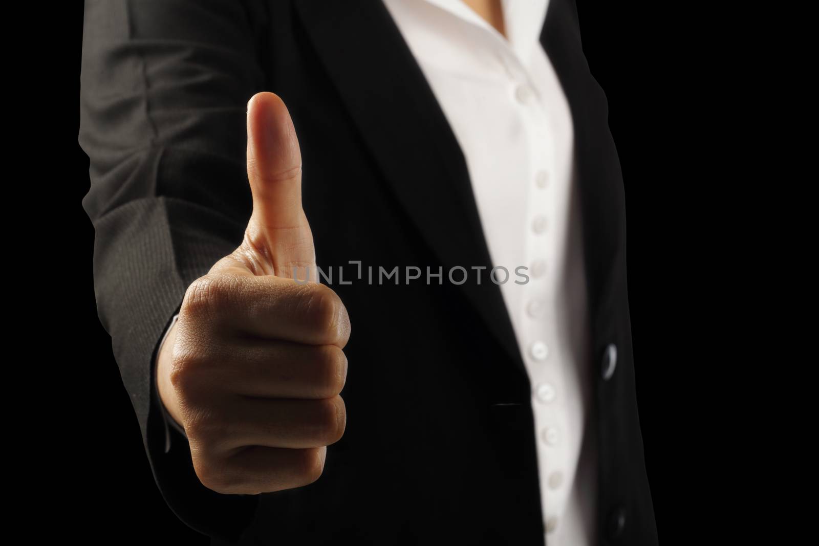 Businesswoman's hand showing thumb up sign isolated on black background, clipping path.