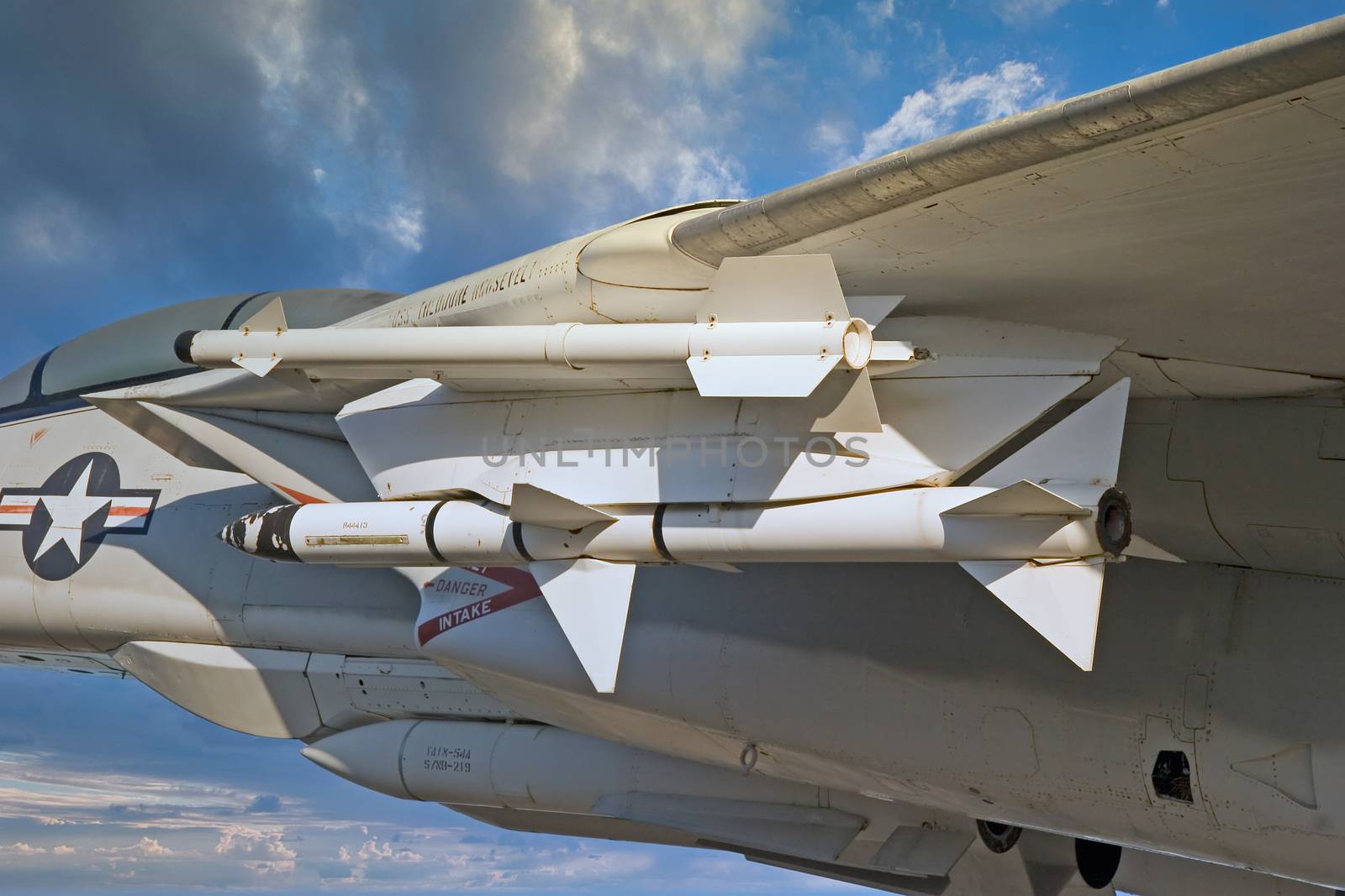 Missiles under the wing of a fighter plane against blue sky