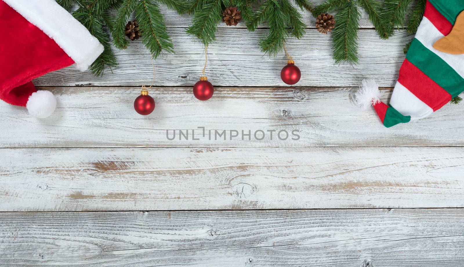 Top border of Christmas decorations on rustic white wooden backg by tab1962