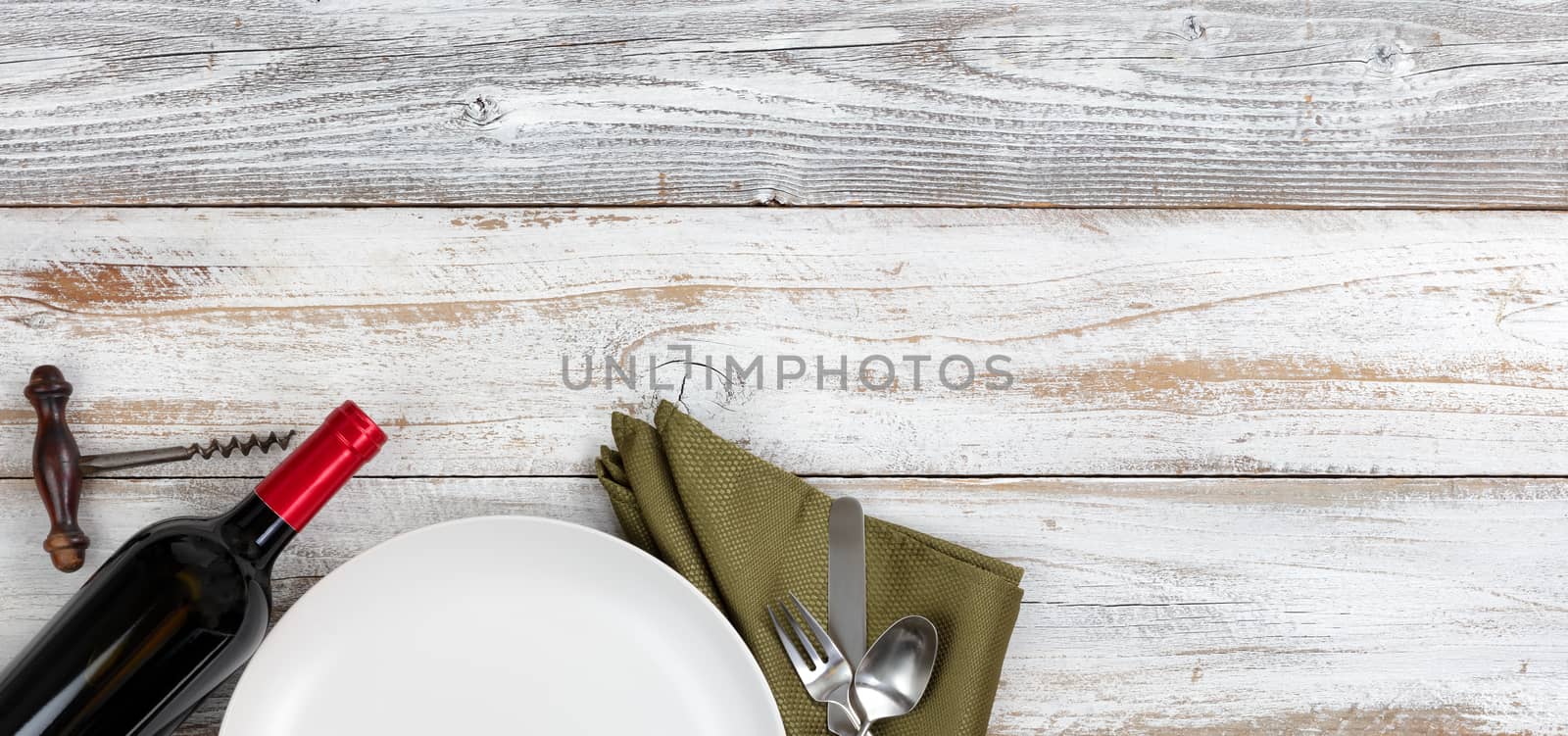 Top view of clean dinner plate setting with red wine on white ru by tab1962