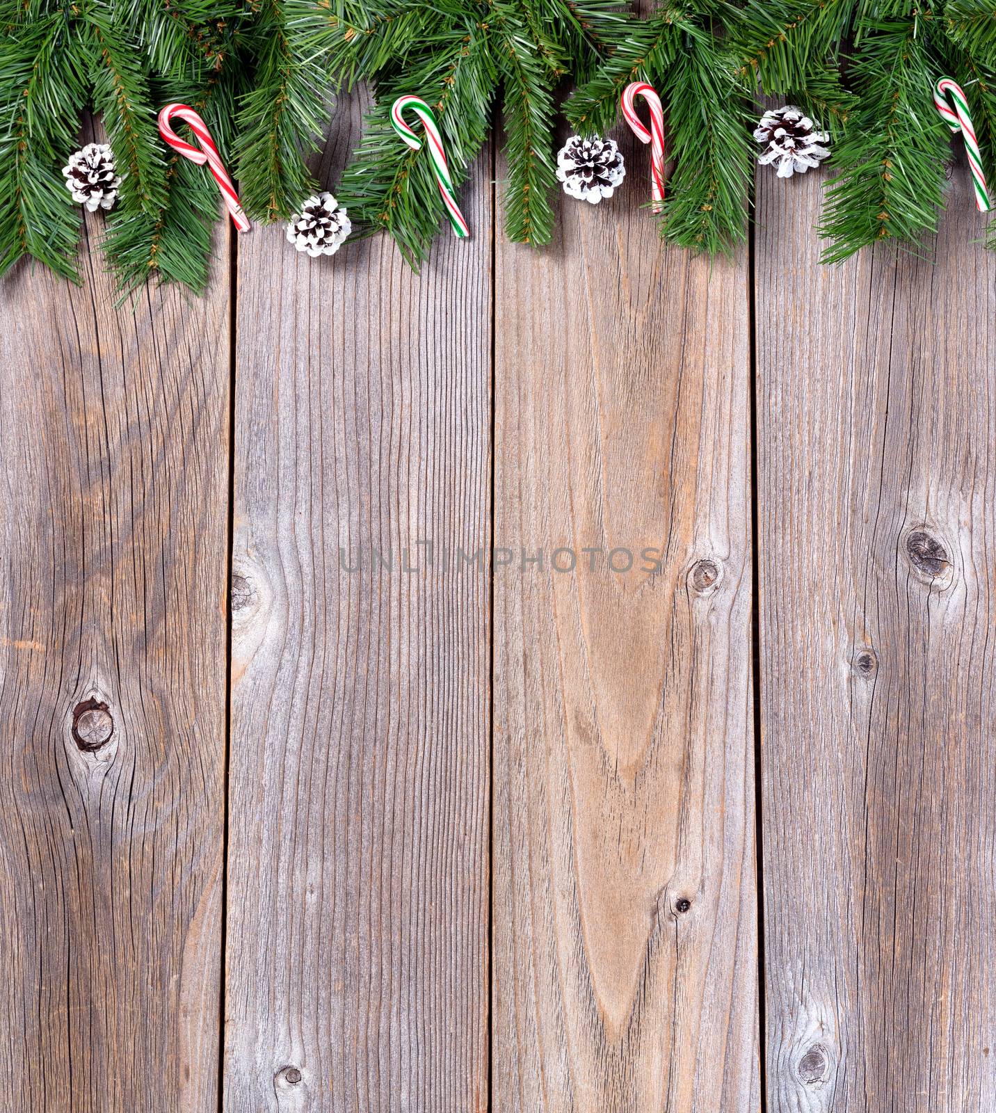 Xmas holiday wooden background with fir branches and candy canes by tab1962