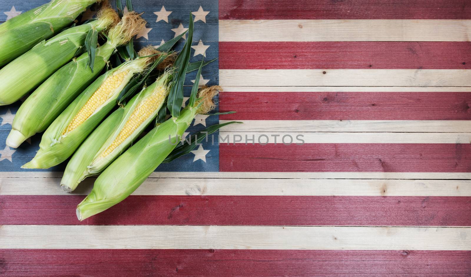 Fresh sweet corn on faded wooden flag of United States of Americ by tab1962