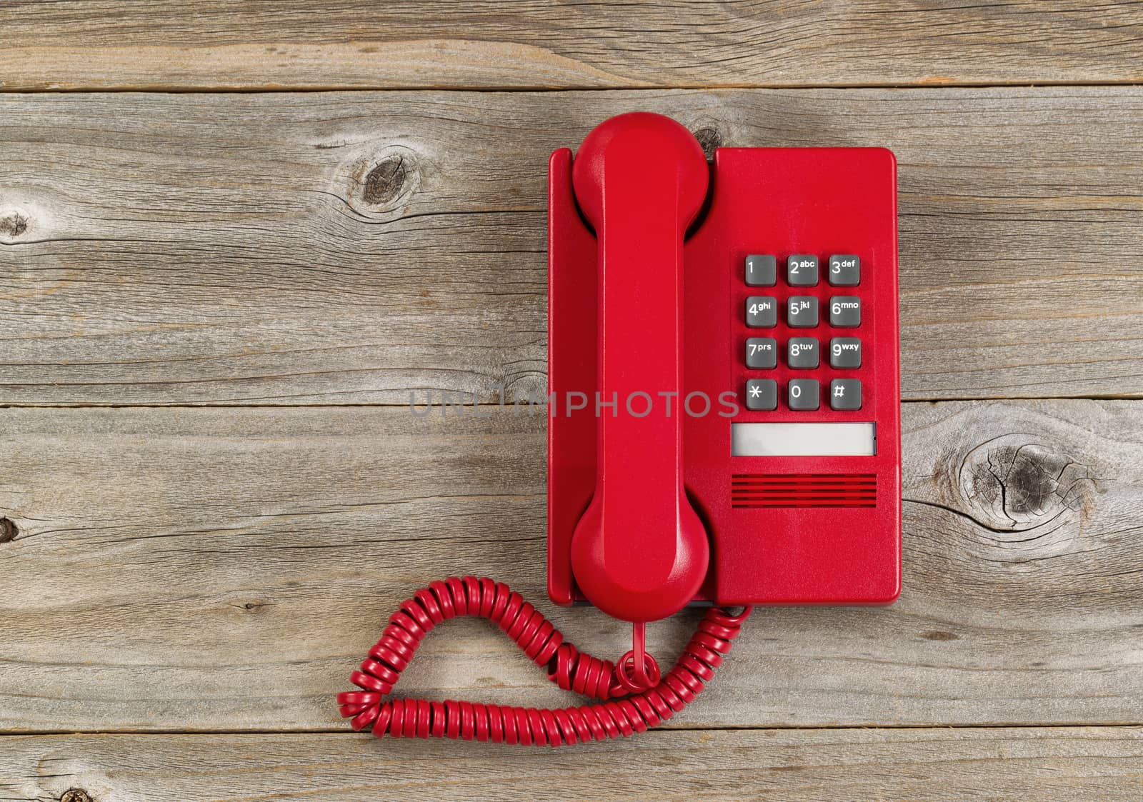 Vintage red phone on rustic wooden boards. High angled view. 

