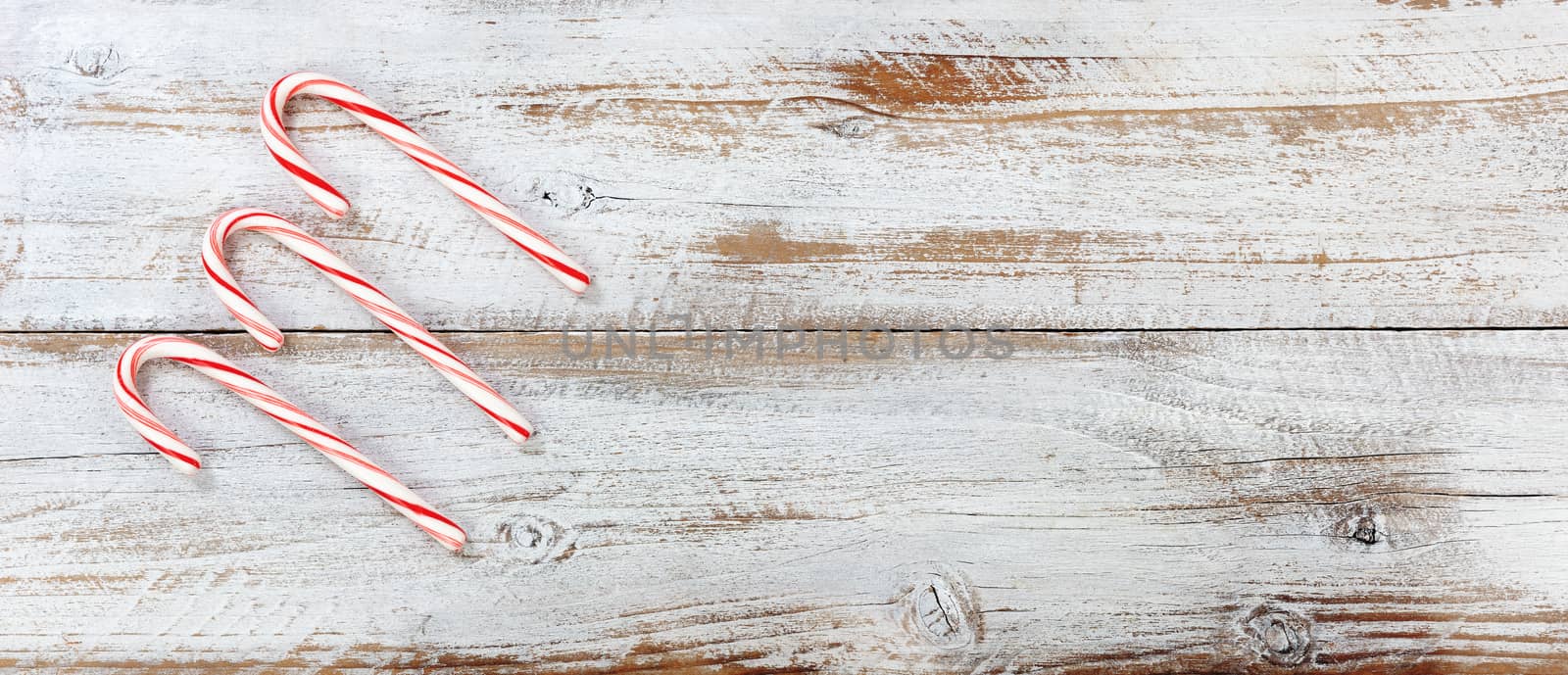Christmas candy canes on rustic white wooden boards 