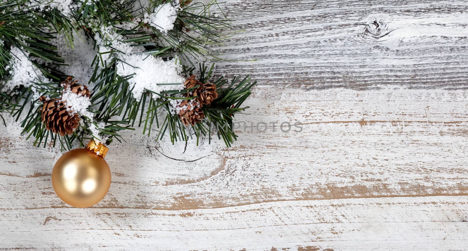 Christmas gold ornament hanging from snowy rough fir tree branch by tab1962