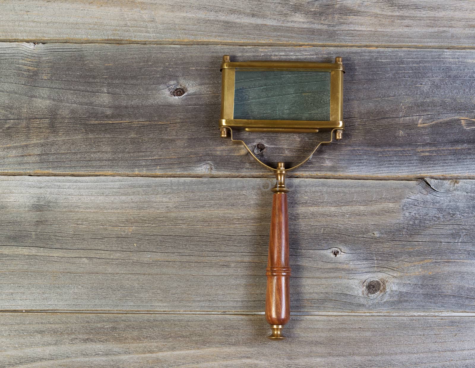 old rectangular shaped magnifying glass on rustic wood  by tab1962