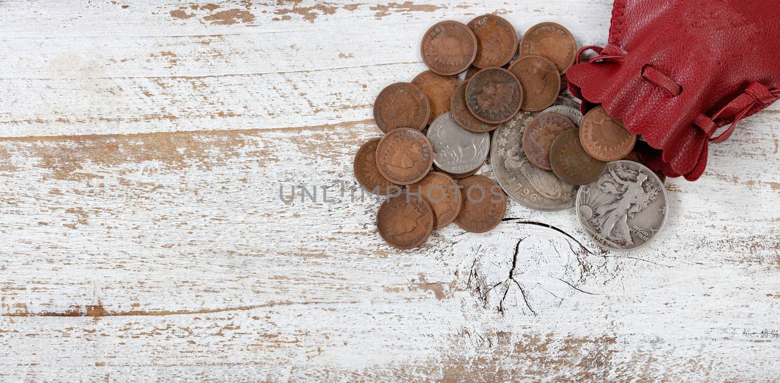 Leather bag of rare United States coins on white rustic wood by tab1962