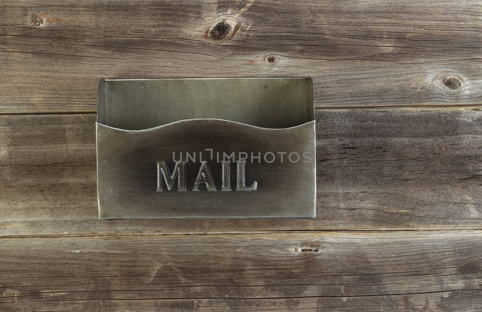 Overhead view of an empty old metal mailbox on rustic wooded boards