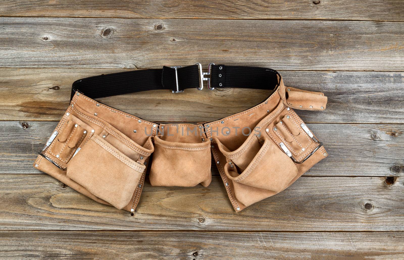 Leather tool belt on rustic wooden boards  by tab1962