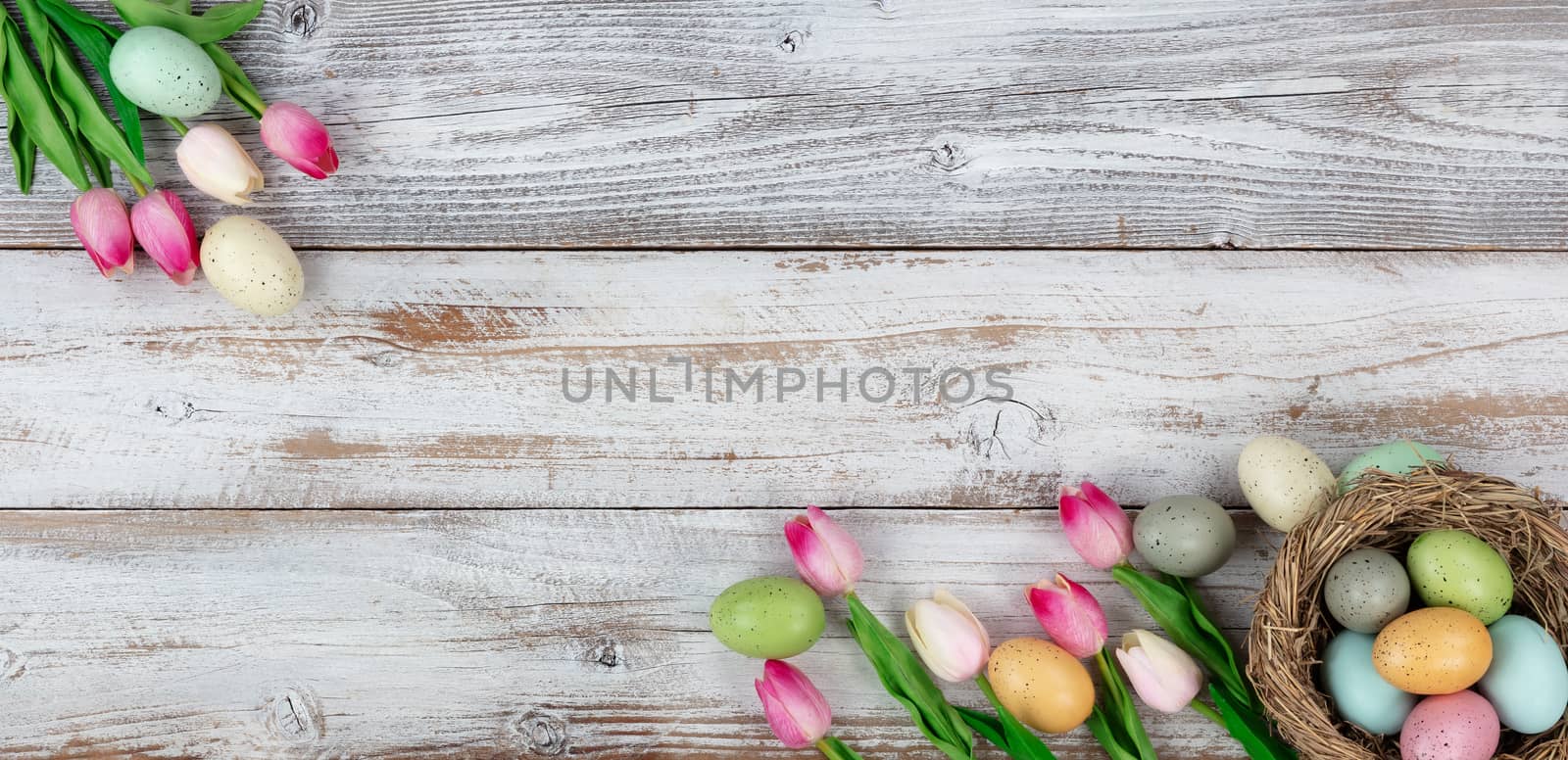 Springtime tulips and colorful eggs on rustic wooden boards for  by tab1962