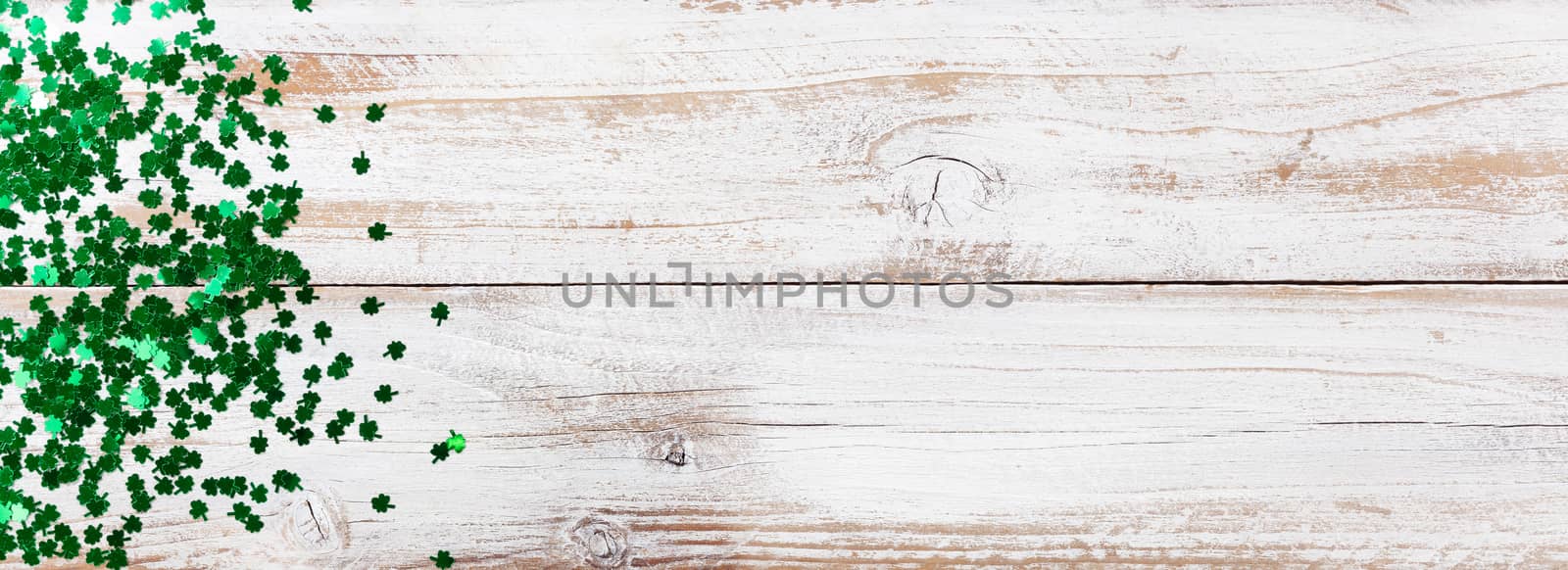Bright green shamrock for Saint Patrick Day on white rustic wooden background 