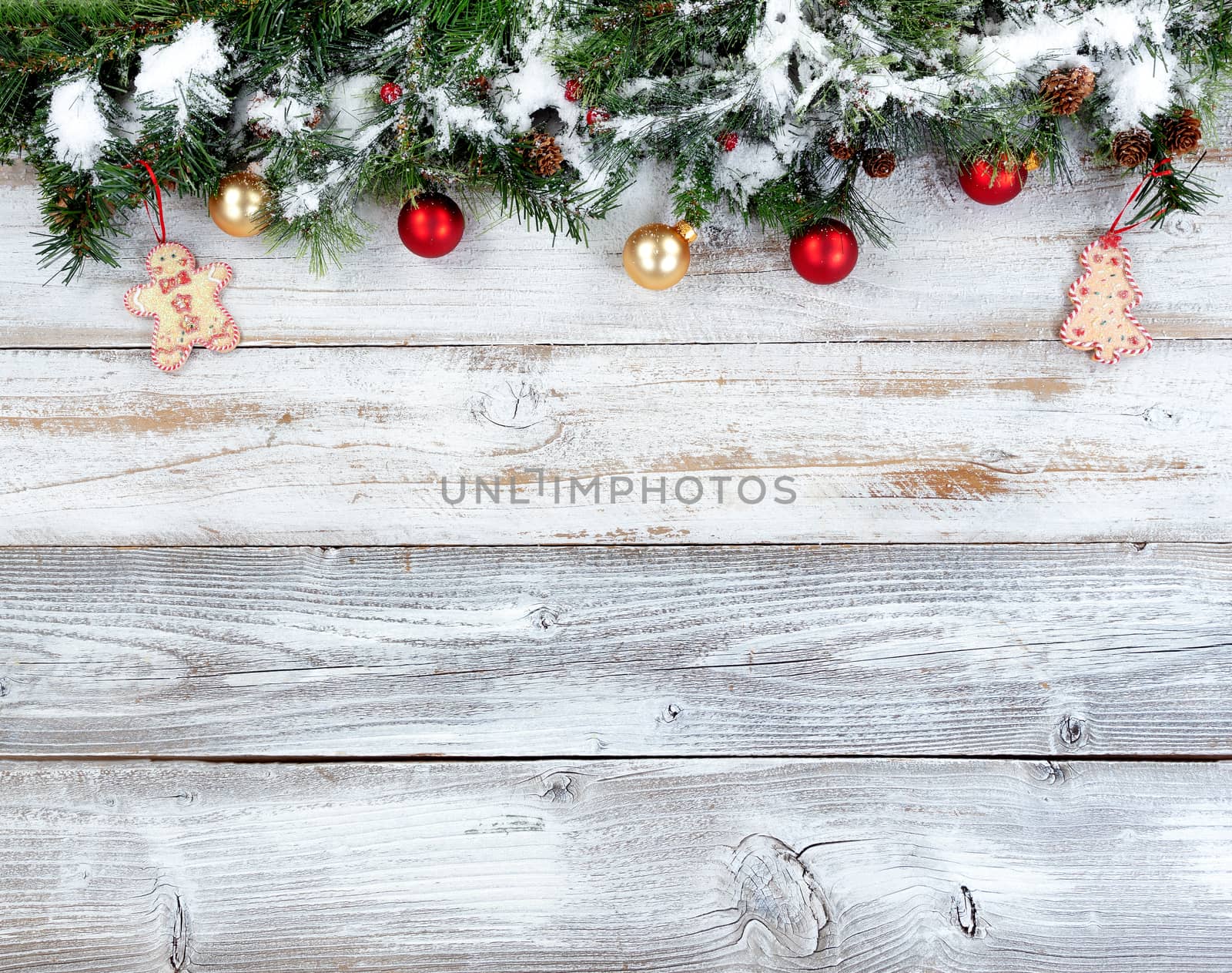 Christmas evergreen branches with other holiday decorations on white rustic wood