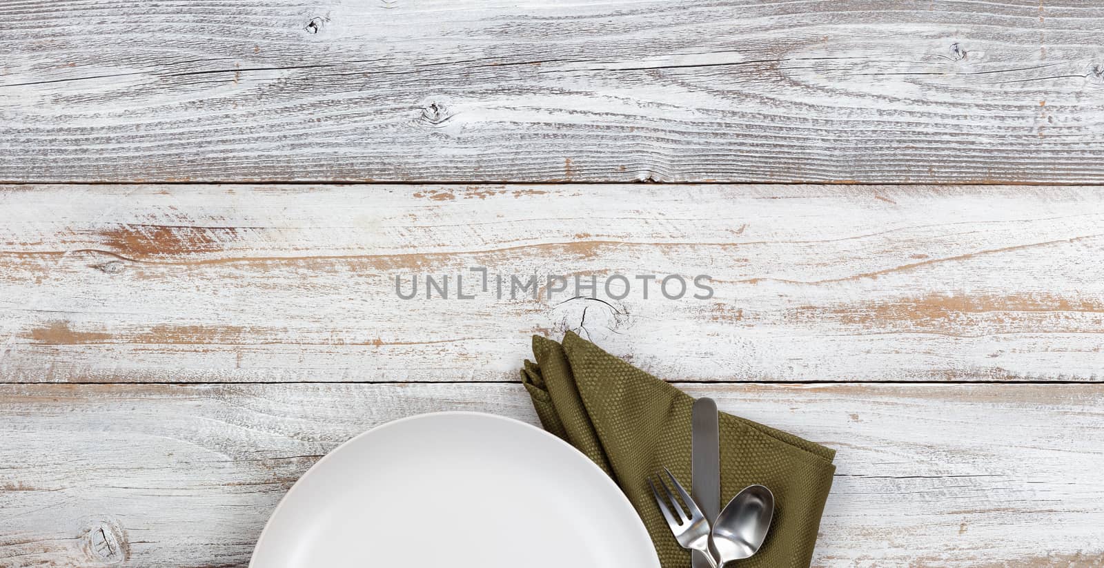 Top view of clean dinner plate with green napkin and silverware  by tab1962