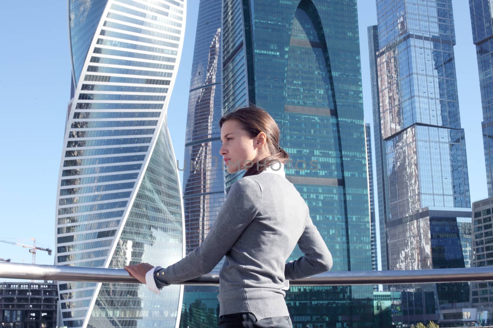 Stressed business woman in the city over skyscrapers background