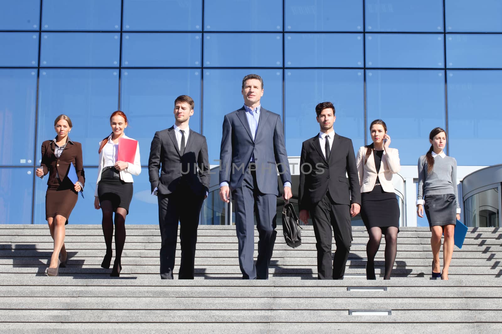 Business people walking together on stairs over skyscraper background