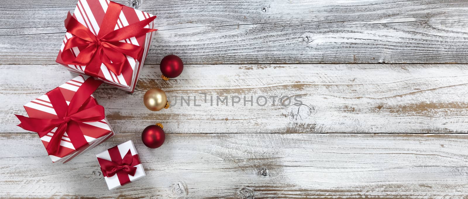 Merry Christmas with gifts and ball ornaments on white rustic wooden background for the holiday