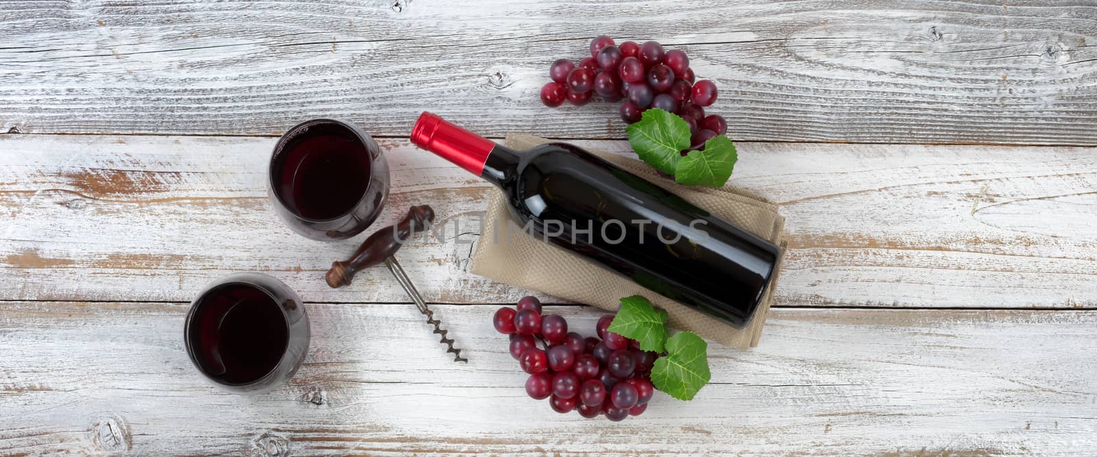 Red wine ready to drink with full bottle and grapes on white wea by tab1962