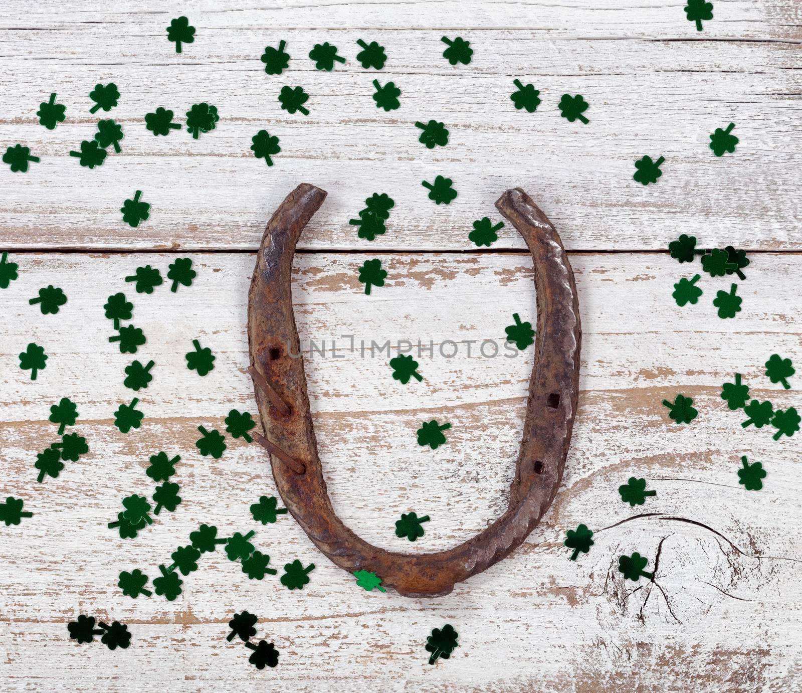 Rusty horseshoe with shinny clovers for St Patrick Day by tab1962