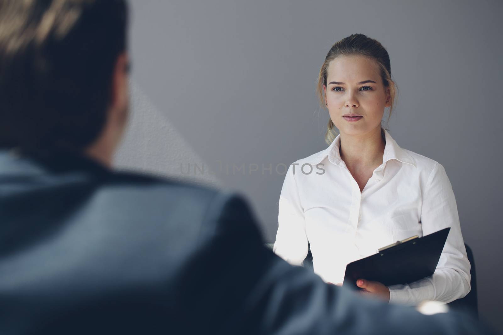 Portrait of a young woman sitting in front of man during a job interview