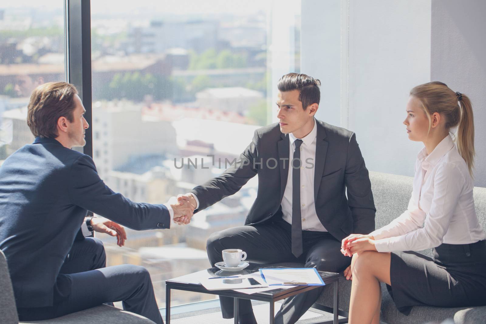 Interviewer shaking hand of an interviewee during a job interview in office