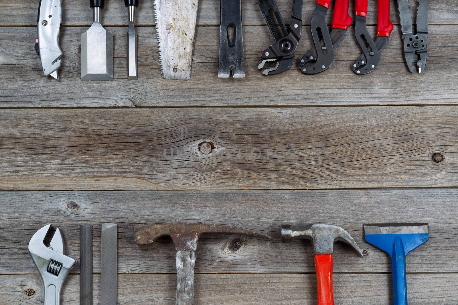 Top view of basic used partial tools forming border on rustic wooden boards. 