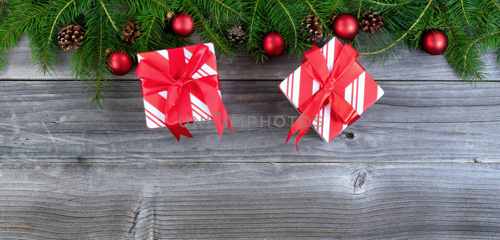 Overhead view of real fir Christmas tree branches with gifts on weathered wood  