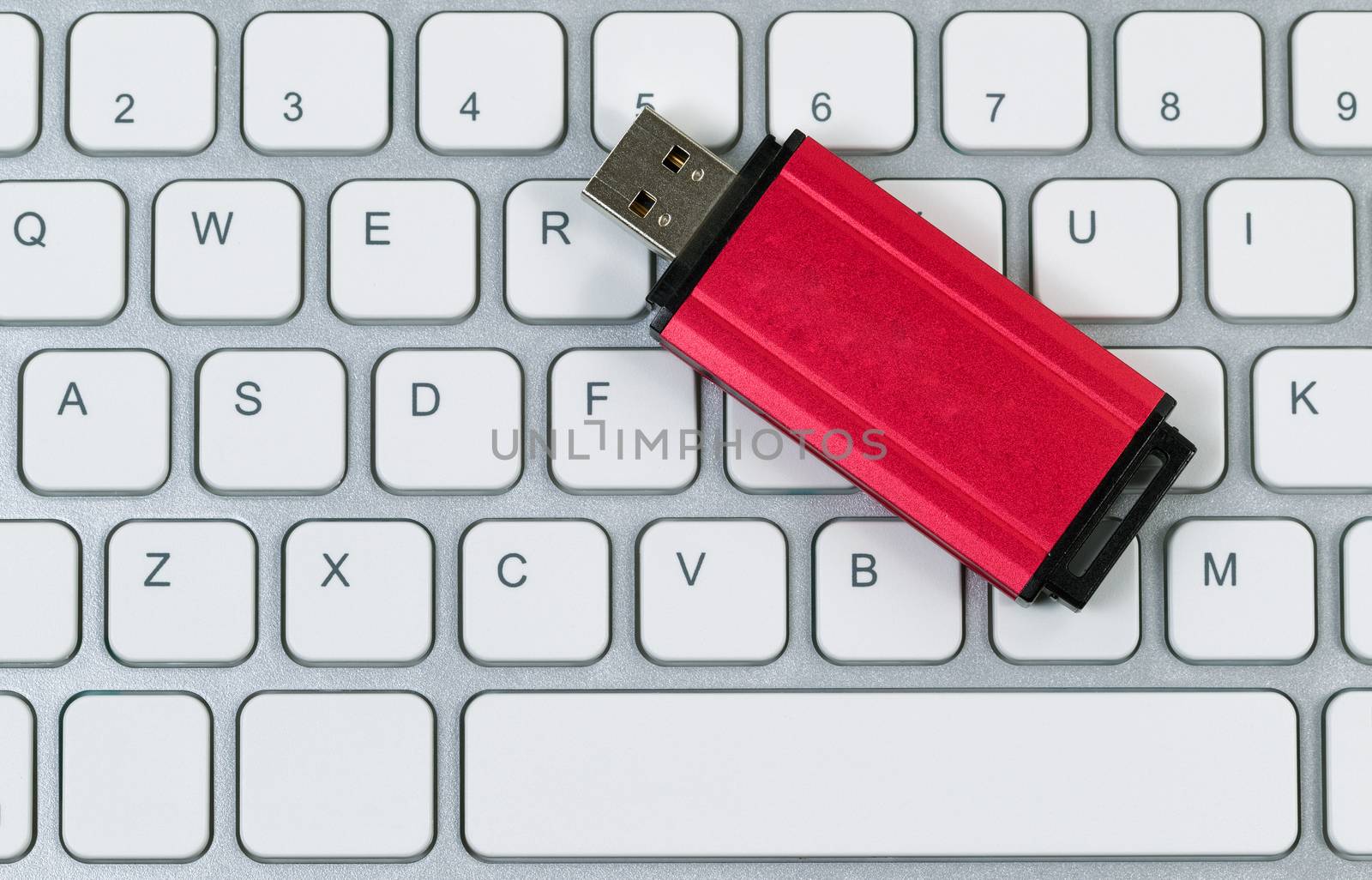 Close up view of data thumb drive and computer keyboard. Modern data technology concept. 