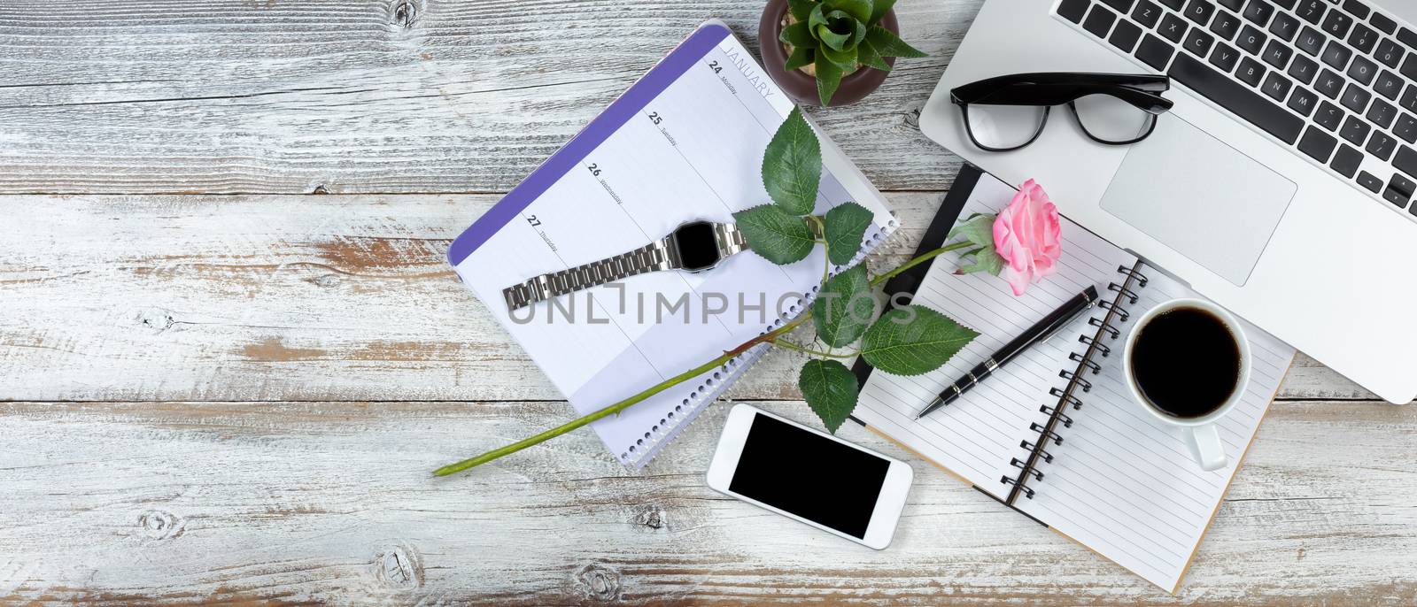 Overhead view of office desktop with lovely pink rose on white r by tab1962