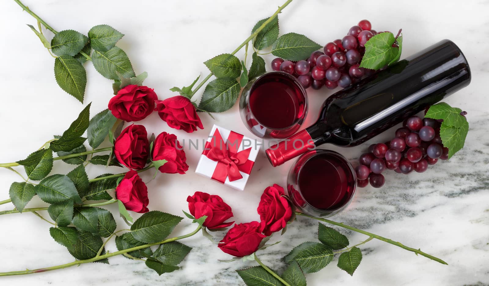 Romantic setting with red wine and roses on marble stone backgro by tab1962