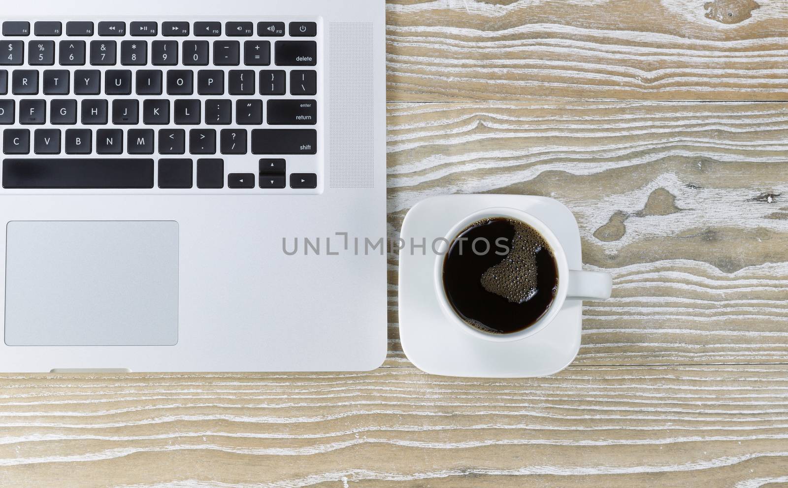 Top view shot of an old white desktop with laptop and black coffee. Layout in horizontal format.