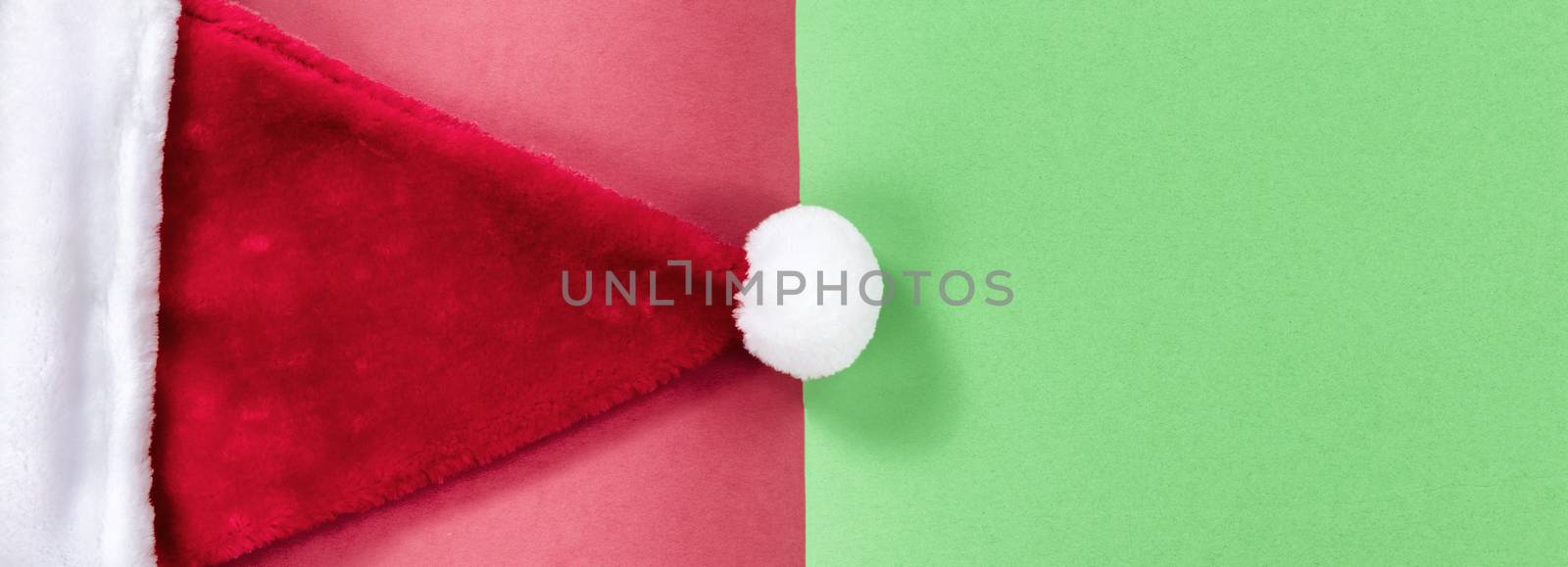 Red and green background with Santa Claus cap for Christmas season 