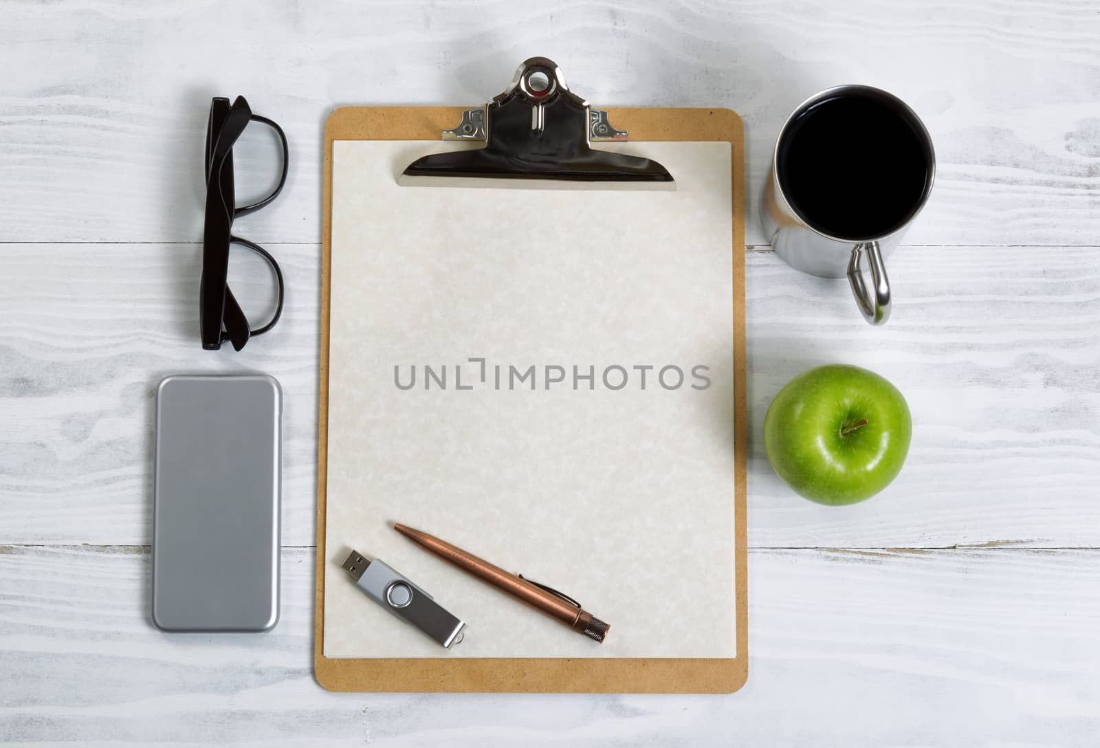 Clipboard with office supplies and snack foods on a white wooden by tab1962