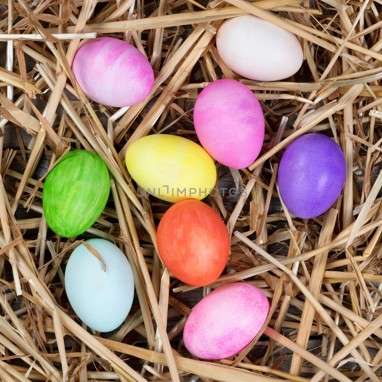 Colorful eggs for Easter holiday on natural straw and rustic woo by tab1962
