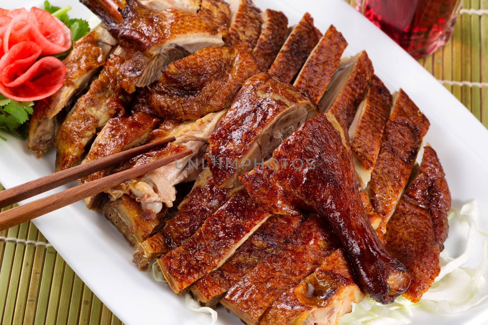 Chinese crispy roasted duck with red wine on natural bamboo mat